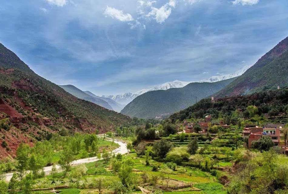 Scenic view of the picturesque Ourika Valley in Morocco, surrounded by majestic mountains and lush greenery.