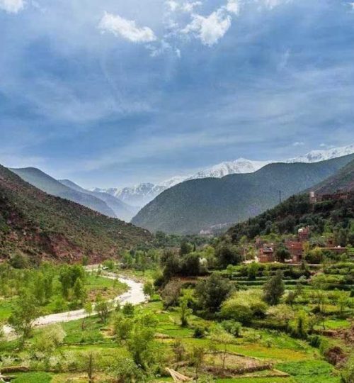 Scenic view of the picturesque Ourika Valley in Morocco, surrounded by majestic mountains and lush greenery.